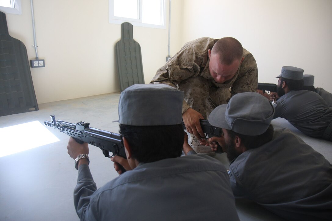 Lance Cpl. Joshua S. Bunn, Company F, 2nd Battalion, 7th Marine Regiment adjusts an Afghan National Police Recruits firing position on Lashkar Gah, June 4. 2nd Battalion 7th Marines, based out of Marine Air Ground Combat Center 29 Palms, is a reinforced light infantry battalion deployed to Afghanistan in support of Operation Enduring Freedom.