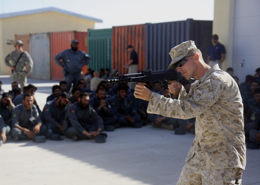 Cpl. Cory J. Becker, Company G, 2nd Battalion, 7th Marine Regiment demonstrates to Afghan National Police Recruits firing positions with the AMD-65 on Lashkar Gah, June 3. 2nd Battalion, 7th Marines, based out of Marine Air Ground Combat Center 29 Palms, is a reinforced light infantry battalion deployed to Afghanistan in support of Operation Enduring Freedom.