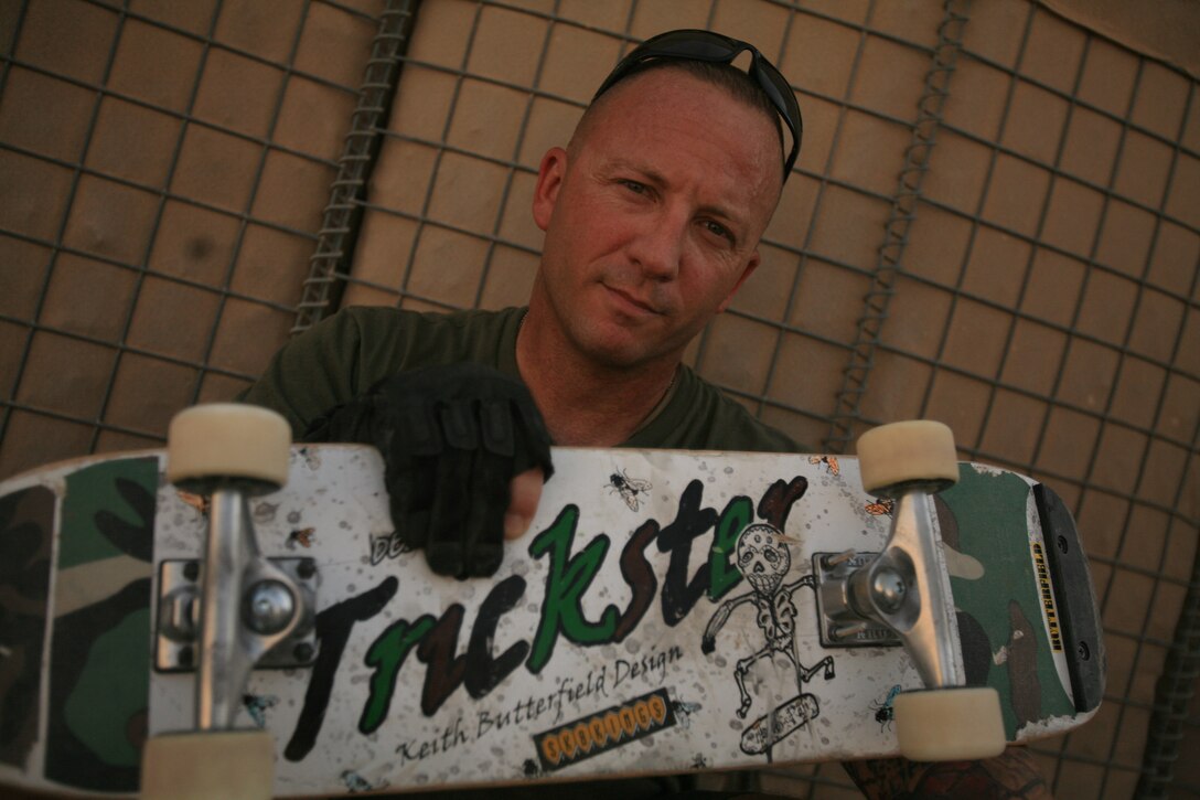 1st Sgt. Keith S. Butterfield, first sergeant, Headquarters and Support Company, 7th Engineer Support Battalion, 22nd Naval Construction Regiment, displays one of the boards that has sponsored him, with his name emblazoned across the bottom of it. Butterfield enjoyed a professional freestyle skateboarding career in the 80?s where he gained notoriety for his signature move, the ?Butterflip.? Years later and a half world away, Butterfield is honing his craft once again to get back to where he was 24-years ago and seeks to inspire others, showing them that skateboarding isn?t just for delinquents. Butterfield is stationed at Camp Taqaddum, Iraq. (Photo by Cpl. Tyler B. Barstow)