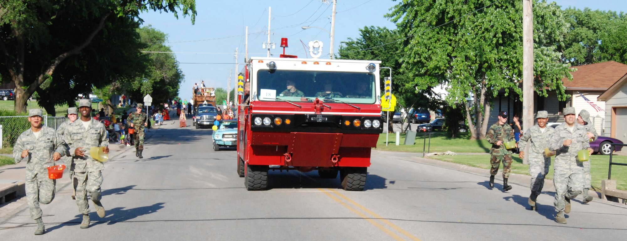 MCCONNELL AIR FORCE BASE, Kan. -- Airmen from McConnell’s First Term Airman’s Center “double-time” their marching to keep up with the flow of the Derby Days parade, May 30, Derby, Kan.  The Airmen handed out candy to the crowd while McConnell’s fire department showcased a fire engine. (Photo by Airman 1st Class Jessica Lockoski)