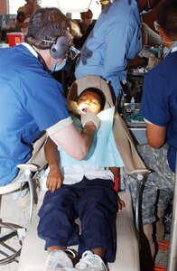 Maj. (Dr.) Stephen Klein, 185th Med. Co., performs a rooot canal on a local Honduran boy during a dental readiness exercise. More than 2200 patients were seen by dentists during Beyond the Horizon 2008. (Courtesy photo)                     
