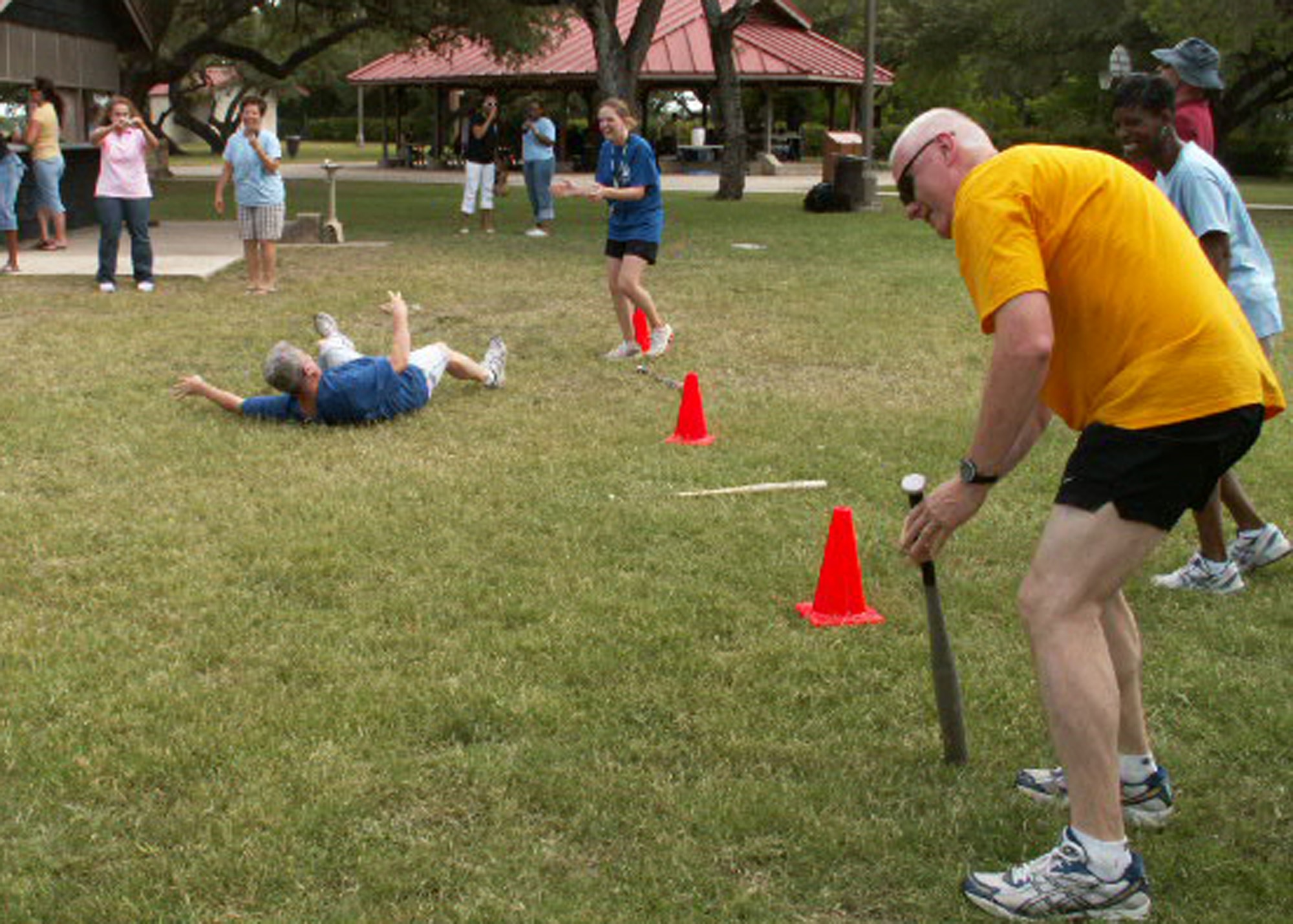 Col. Bill Foote (left), personnel services director, and Chief Master Sgt. Andy Kaiser (right), command chief, both from the Air Force Personnel Center here at Randolph Air Force Base, Texas, attempt to run a straight line after 10 rotations with their foreheads on a bat during AFPC's sports day. Dizzy bat was just one of several untraditional events. (US Air Force photo/Master Sgt. Kat Bailey)