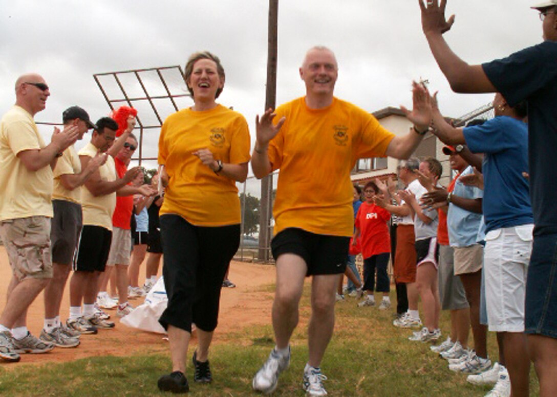 Maj. Gen. K.C. McClain and Chief Master Sgt. Andy Kaiser, Air Force Personnel Center commander and command chief here at Randolph Air Force Base, Texas, run through the rumble tunnel at the opening ceremony of AFPC's sports day June 4. General McClain encouraged all Airmen, civilians and contractors to participate to increase esprit de corps and camaraderie within AFPC. (US Air Force photo/Master Sgt. Kat Bailey)