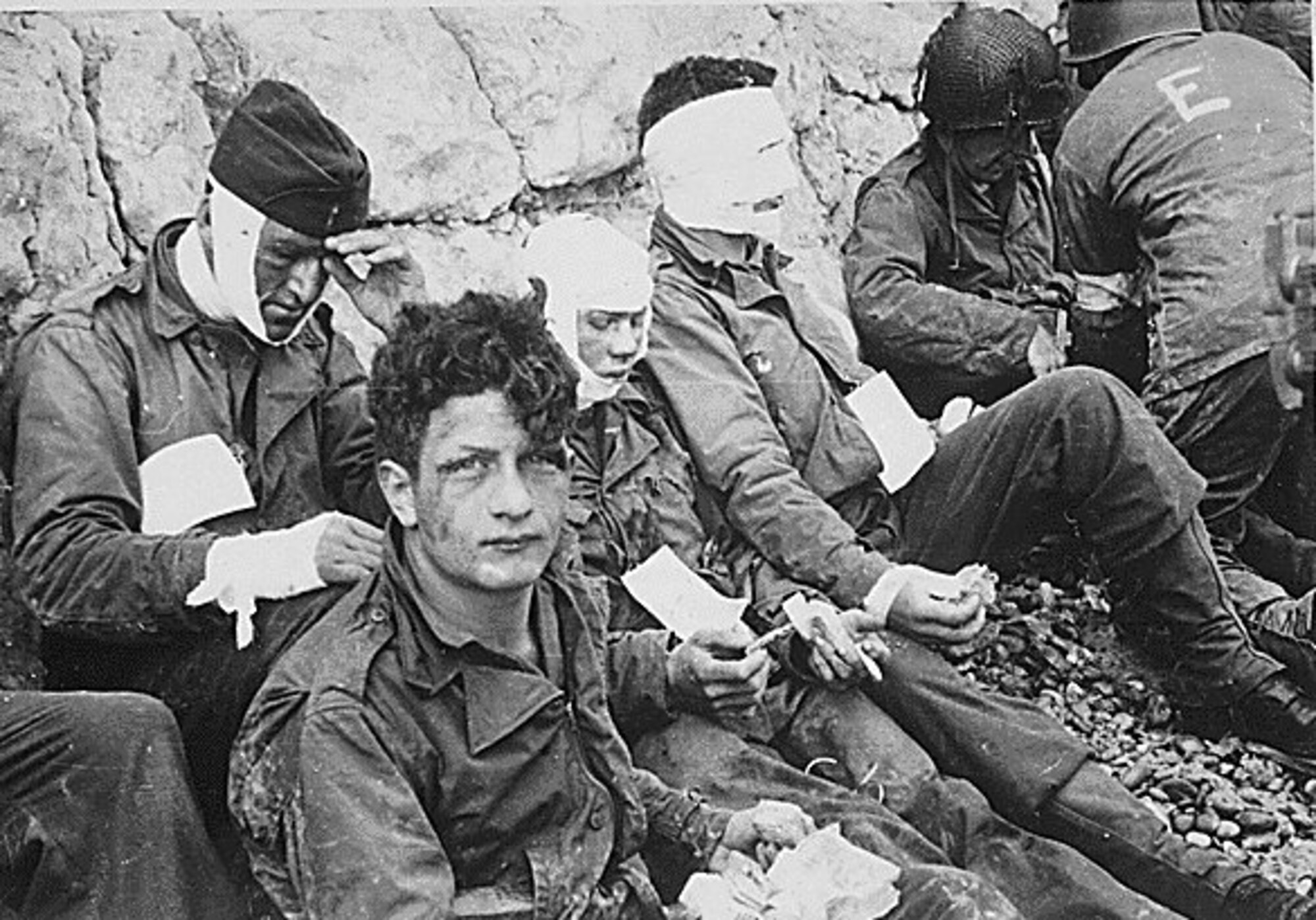 U.S. NATIONAL ARCHIVES -- American assault troops of the 16th Infantry Regiment, injured while storming Omaha Beach, wait by the Chalk Cliffs for evacuation to a field hospital for further medical treatment. Americans landed on two beaches, Omaha and Utah, while Canada and the British took the other three. (courtesy photo)