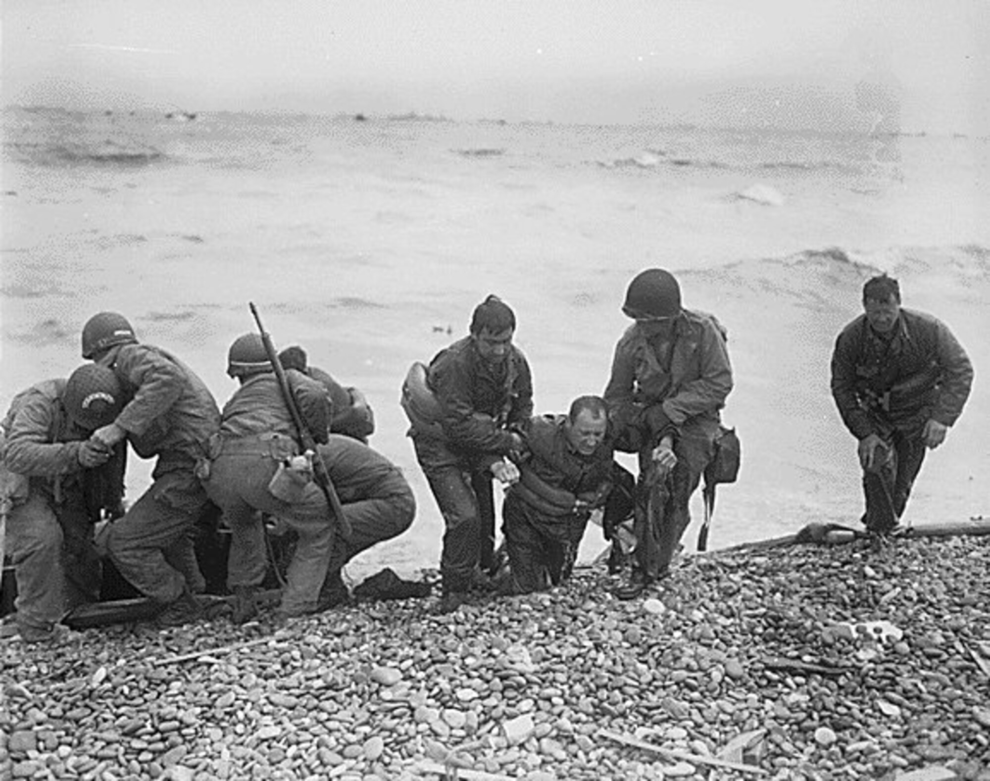 U.S. NATIONAL ARCHIVES -- At Utah Beach, members of an American landing party help others whose landing craft was sunk by the Germans off the coast of France. The survivors reached Utah Beach, near Cherbourg, using a life raft. (courtesy photo)