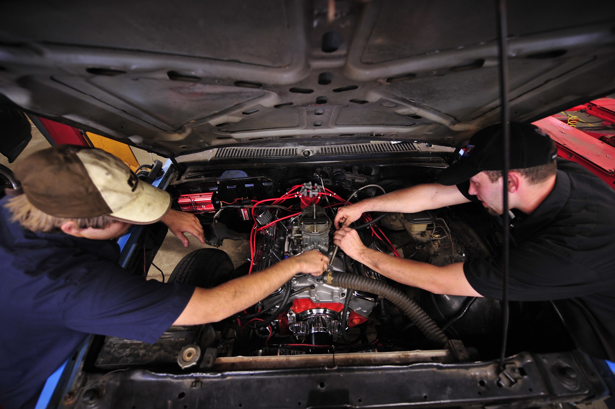 MOODY AIR FORCE BASE, Ga. -- Andrew Kenney, 23rd Force Support Squadron Hobby Shop automotive worker, checks the engine coolant temperature while Roger Stanley, 23rd Force Support Squadron Hobby Shop automotive mechanic, adjusts the tension of the throttle cable on a vehicle here June 5. The Hobby Shop offers competitive pricing for their automotive services.  (U.S. Air Force photo by Senior Airman Elizabeth Rissmiller) 