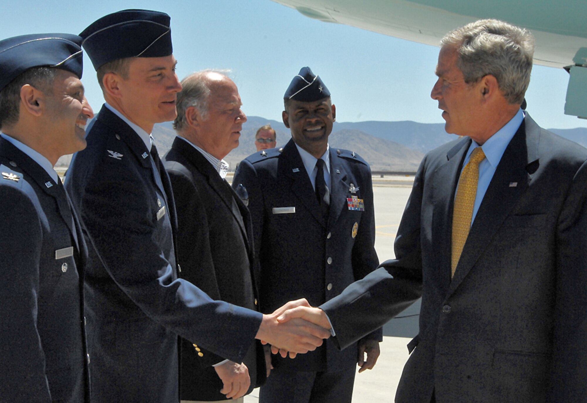 President George W. Bush is greeted by Col. Robert E. Suminsby Jr., 377th Air Base Wing commander. President Bush arrived at Kirtland AFB May 27 in route to Albuquerque for a fund raiser. To Colonel Suminsby?s far left is Brig. Gen. Everett H. Thomas, Air Force Nuclear Weapons Center commander, to his immediate left is Sherman McCorkle, president and CEO of Technology Ventures Corporation, and to his right is Col. Mohsen Parhizkar, 377th ABW vice commander. U.S. Air Force photo by Todd Berenger