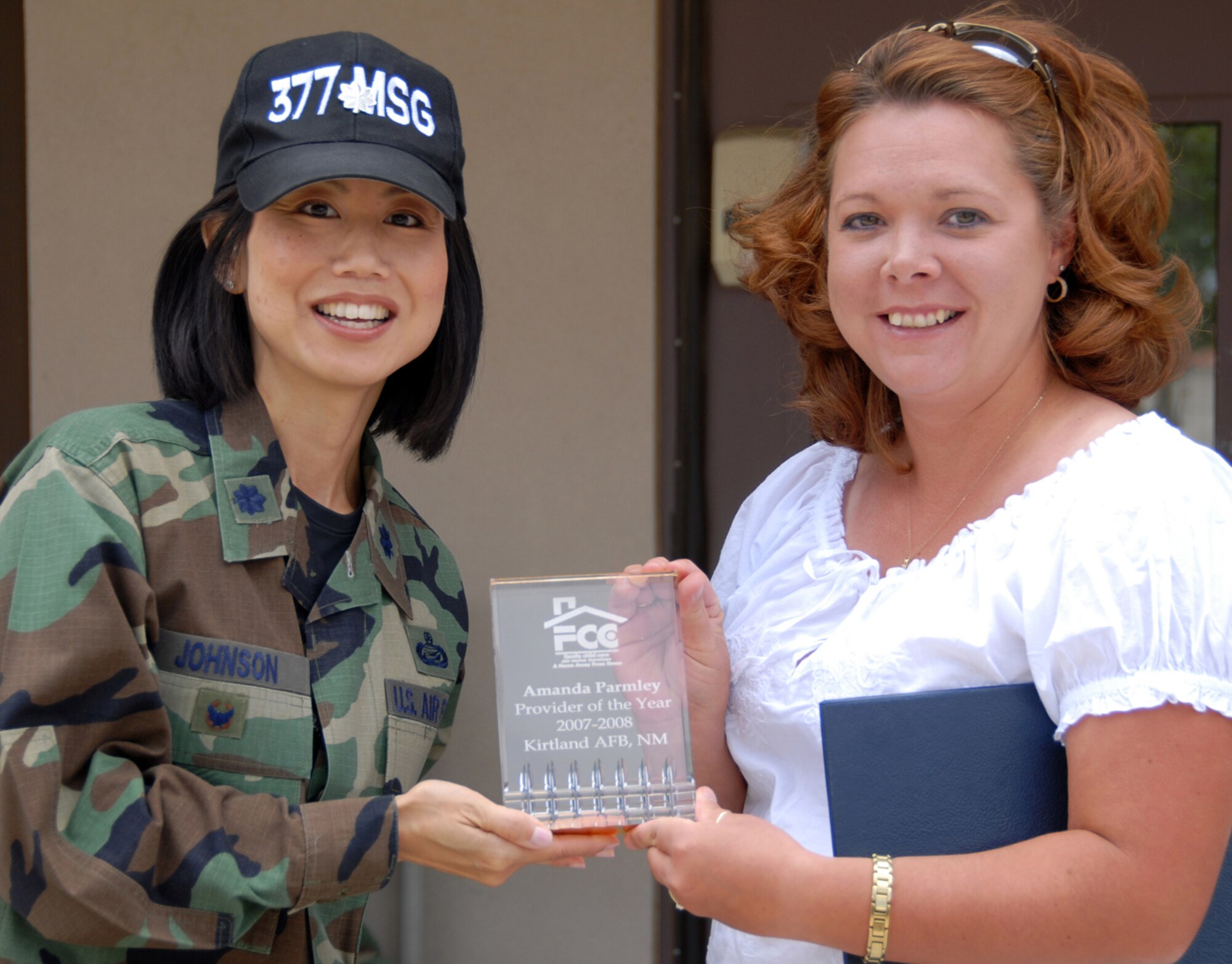 Lt. Col. Emi Johnson, left, 377th Mission Support Group deputy commander, presents Amanda Parmley with the ?Child Car Provider of the Year? award May 9 at the Child Care Provider Picnic held by 377th Services Squadron and the Maxwell Child Development Center. U.S. Air Force photo by Elizabeth Martinez