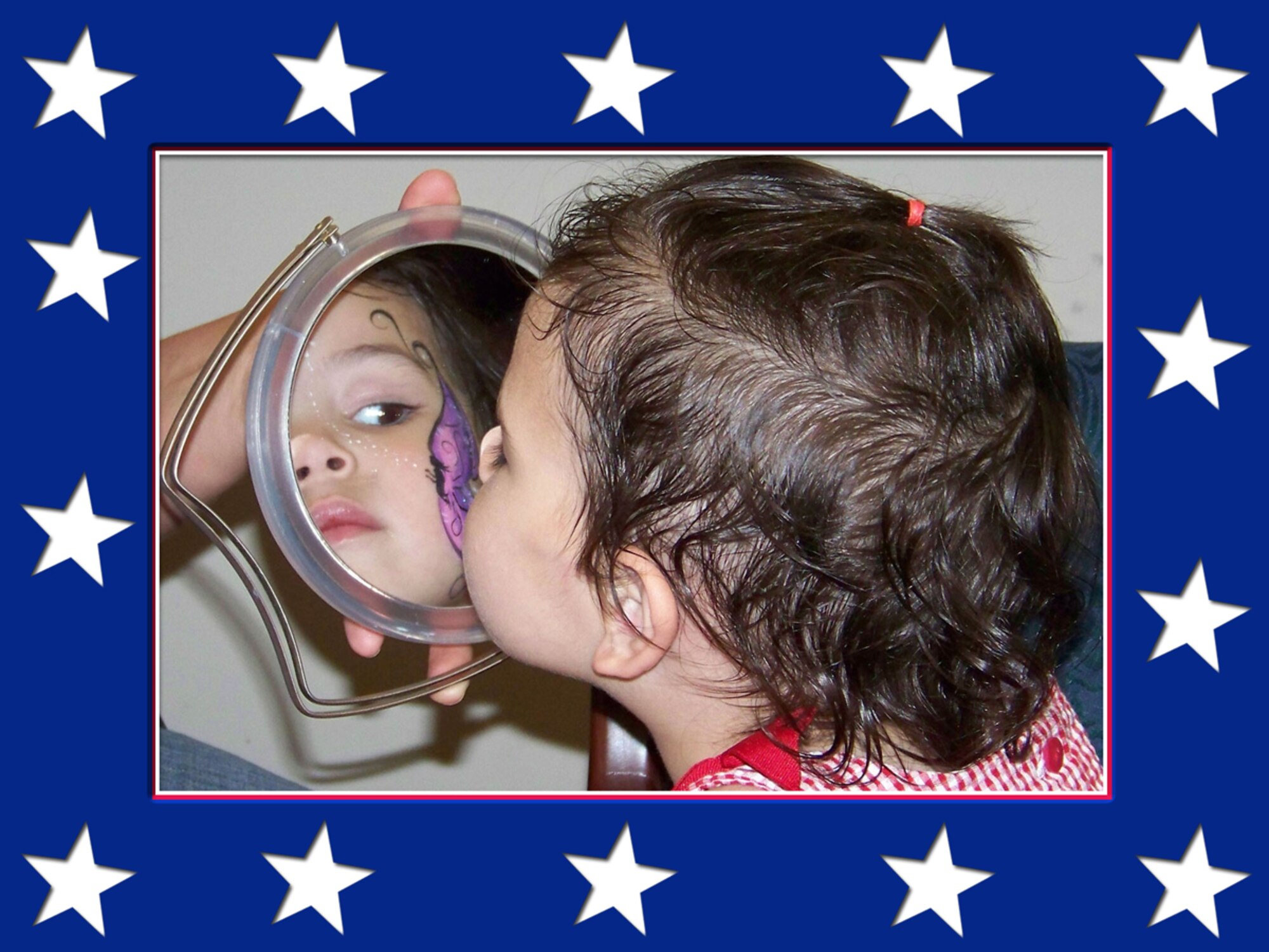 Sarah Smith, daughter of Tech. Sgt. Steve Smith, 917th Security Forces Squadron, gets a glimpse of her face paint in the mirror during the 917 SFS Family Day Wednesday, June 4, Barksdale AFB, La. (U.S. Air Force photo/Master Sgt. Sherri Bohannon)