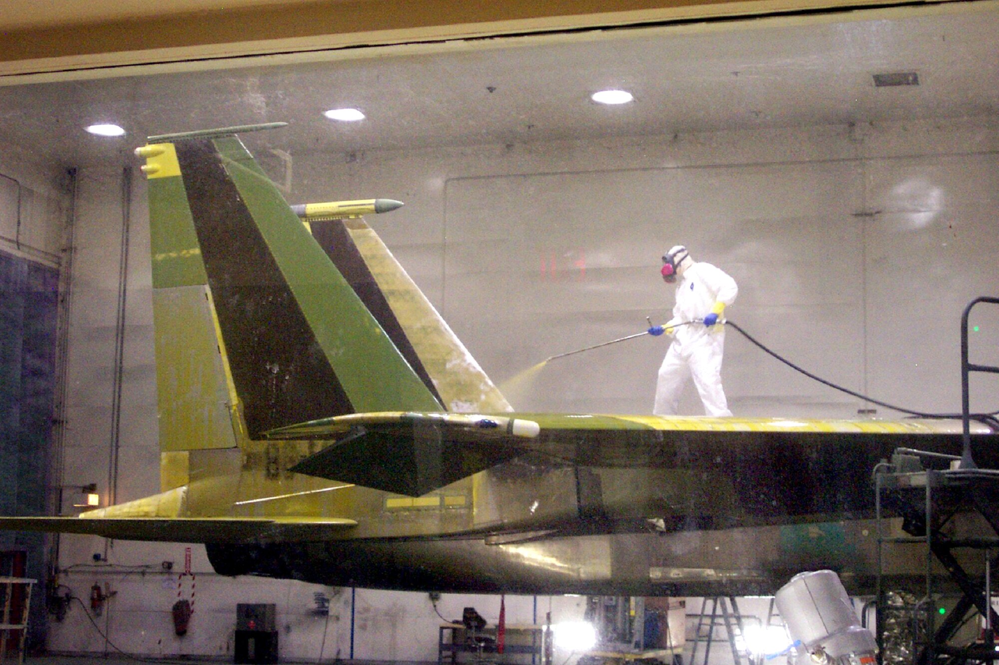 Robins AFB implemented an Alodine Reduction Plan, which decreased chrome usage in the F-15 Paint Facility by 85% and substantially reduced personnel health/safety risks associated with chromate aerosols.  This employee shown is utilizing the manual Alodine spray application system. Courtesy photo  