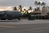 The sun sets on Hickam Air Force Base, Hawaii, base operations center Wednesday evening as Staff Sgt. Thomas C. Dickens, a crew chief assigned to the 735th Air Mobility Squadron, prepares a 15th Airlift Wing C-17 for an Air Mobility Command mission. Tonight when the sun sets SSgt. Dickens will be a part the 515th Air Mobility Operations Wing at Hickam AFB.  (U.S. Air Force photo/MSgt. Robert Burgess)