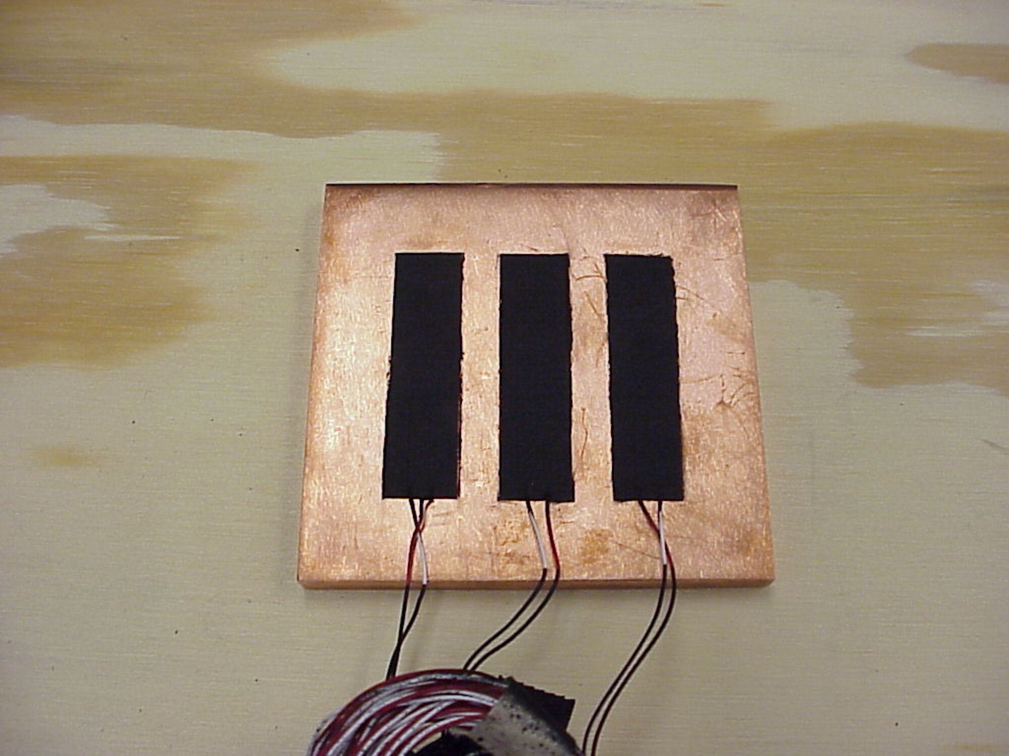 Three heat flux sensors are shown after being attached to a copper plate. Pictures are courtesy of Sensortek Inc. and ATEC Inc.