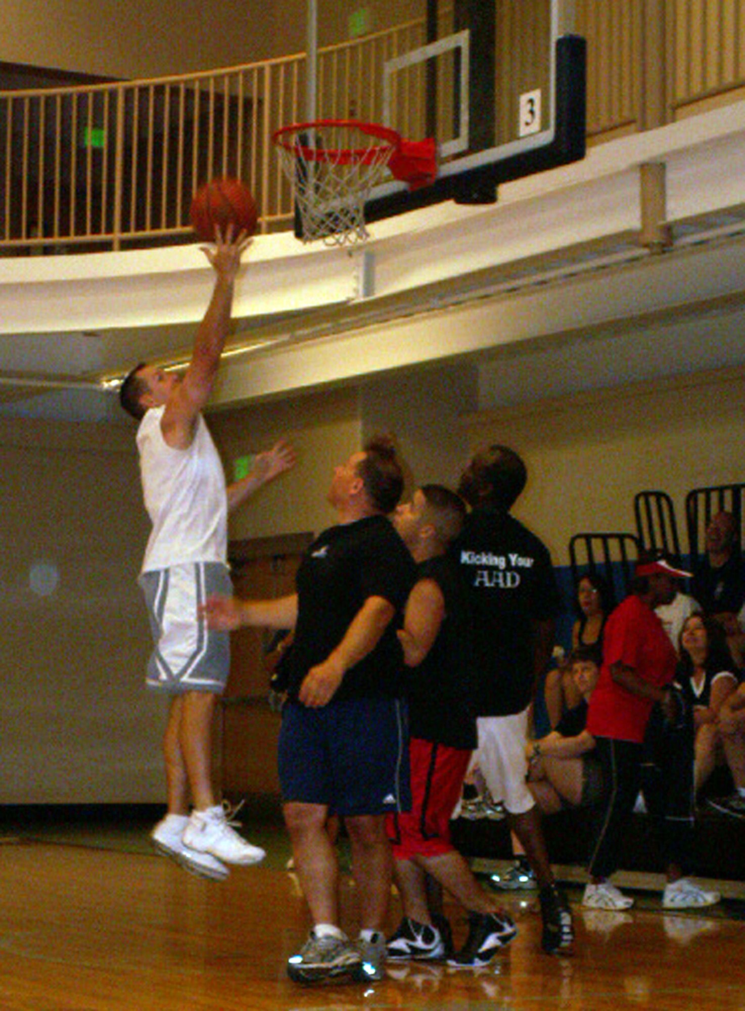 Staff Sgt. Todd Farrell snags the rebound during 3-on-3 basketball at the Air Force Personnel Center's sports day here at Randolph Air Force Base, Texas, here June 4. The defenders (center) are Chuck Cyr and Justin Gonzales while Sergeant Farrell's teammate, Master Sgt. Ken Pittman stands ready to assist. The Airmen work in assignments while the two civilians are part of the directorate of civilian force integration. (US Air Force photo/Master Sgt. Kat Bailey) 