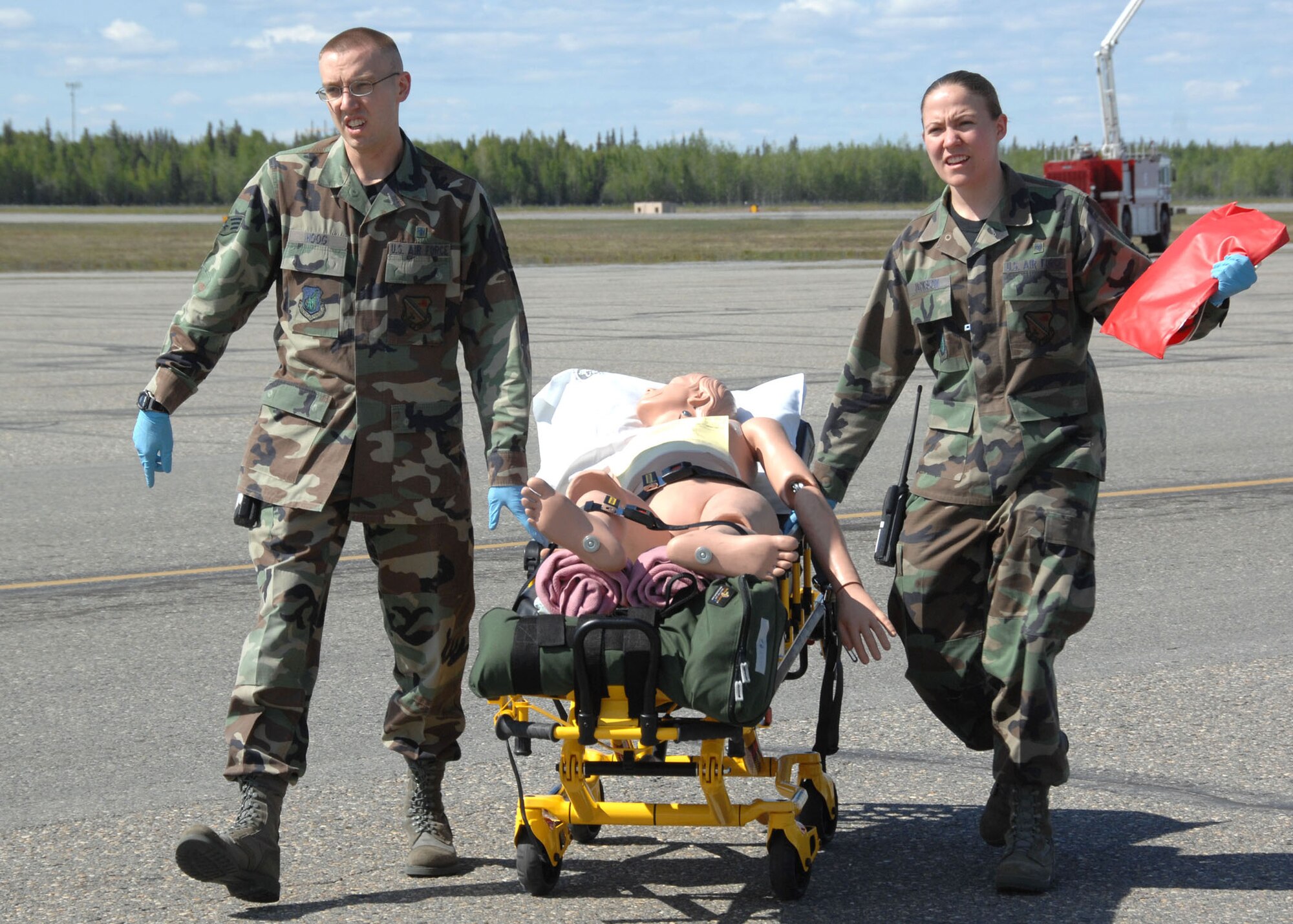 Senior Airman Tucker Hoog and Airman 1st Class Ashley Jackson respond to a simulated aircraft accident to assist Airmen and Community Members on the flightline during the Emergency Management Exercise here May 30, 2008. The EME prepares emergency teams for real world situations. Airmen Hoog and Jackson are aerospace medical technicians, 354th Medical Support Squadron,
Eielson AFB, Alaska. (U.S. Air Force photo/Staff Sgt. Tia Schroeder)