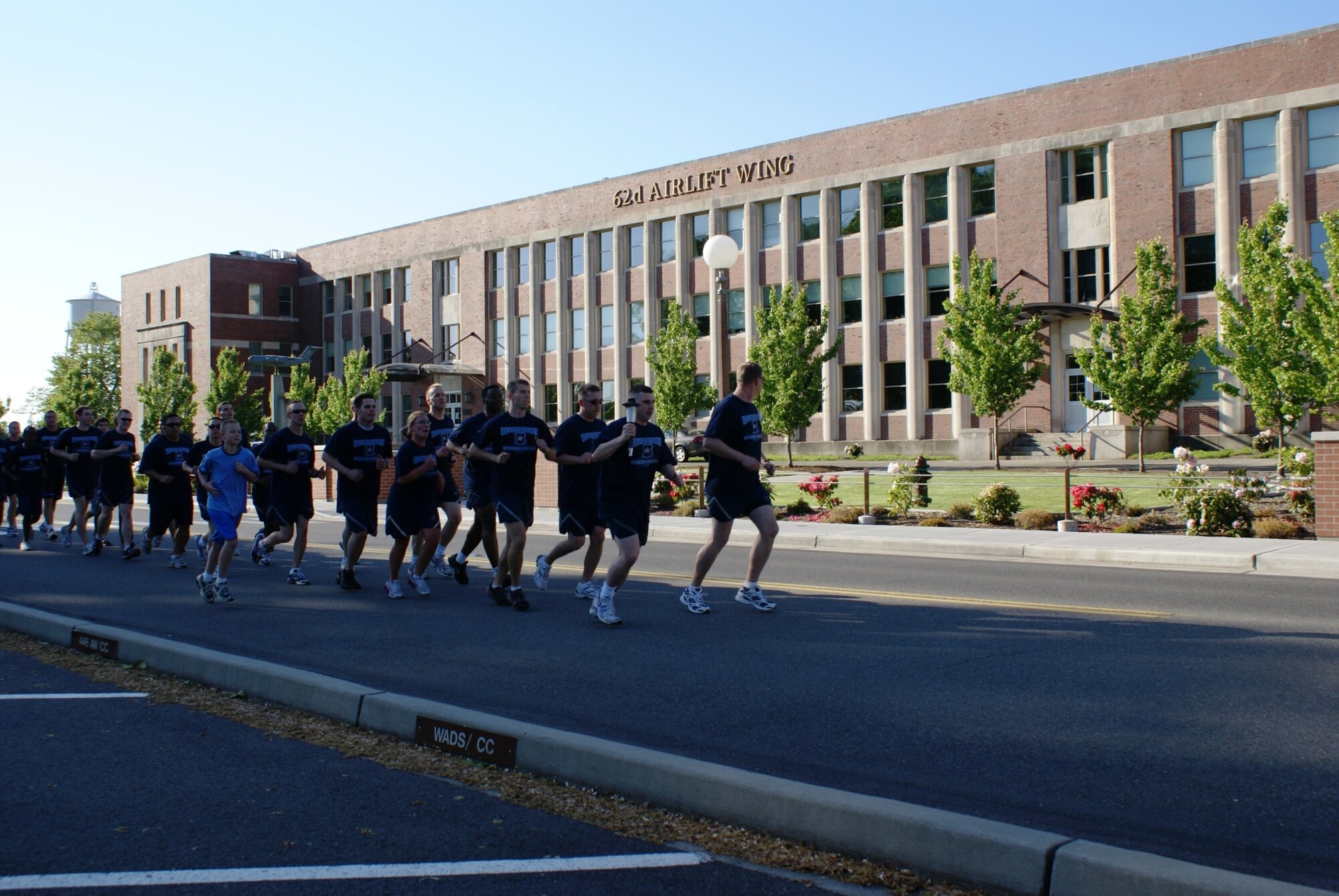 Staff Sgt. Antone Baillie, 62nd Security Forces Squadron, carries the torch along with security forces members and Washington law enforcement officers during the Torch Run May 30. (U.S. Air Force photo/Staff Sgt. Eric Burks)