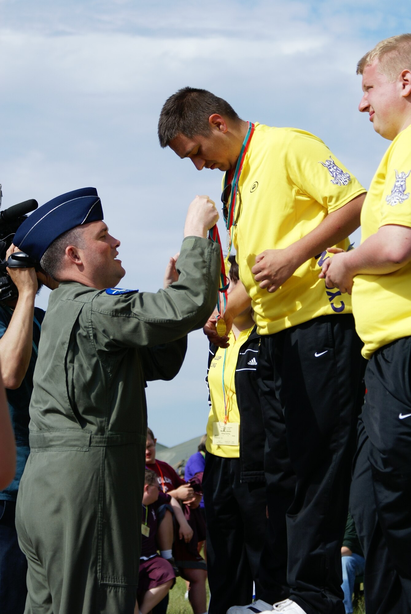 Lt. Col. Brian Newberry, 7th Airlift Squadron commander, presents medals to the champions of Saturday's cycling events in the annual Washington Special Olympic Summer Games here. McChord and Fort Lewis teamed up again this year to host the Games, which featured competitive events including aquatics, athletics (field events), cycling, powerlifting, and soccer. Saturday and Sunday's cycling events marked the first time that an athletic competition for the Games was held at McChord. (U.S. Air Force photo/Staff Sgt. Eric Burks)