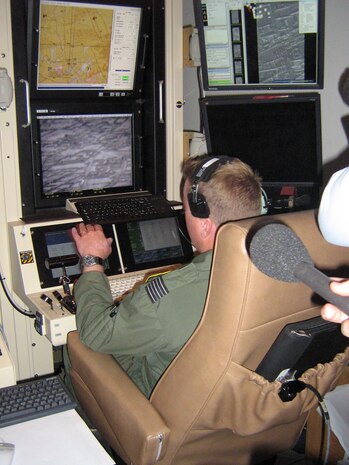 CREECH AIR FORCE BASE, Nev.—Royal Air Force Wing Commander of 39 Squadron, Andy Jeffrey, mans the sensor operator position in the Reaper ground control station during a live mission over Afghanistan.  He worked in tandem with the pilot, Lt. Col. Jon Greene, commander of the 42nd Attack Squadron, as the first two squadron commanders in the joint Coalition Forces to perform an MQ-9 mission—and show it live to non-military personnel.