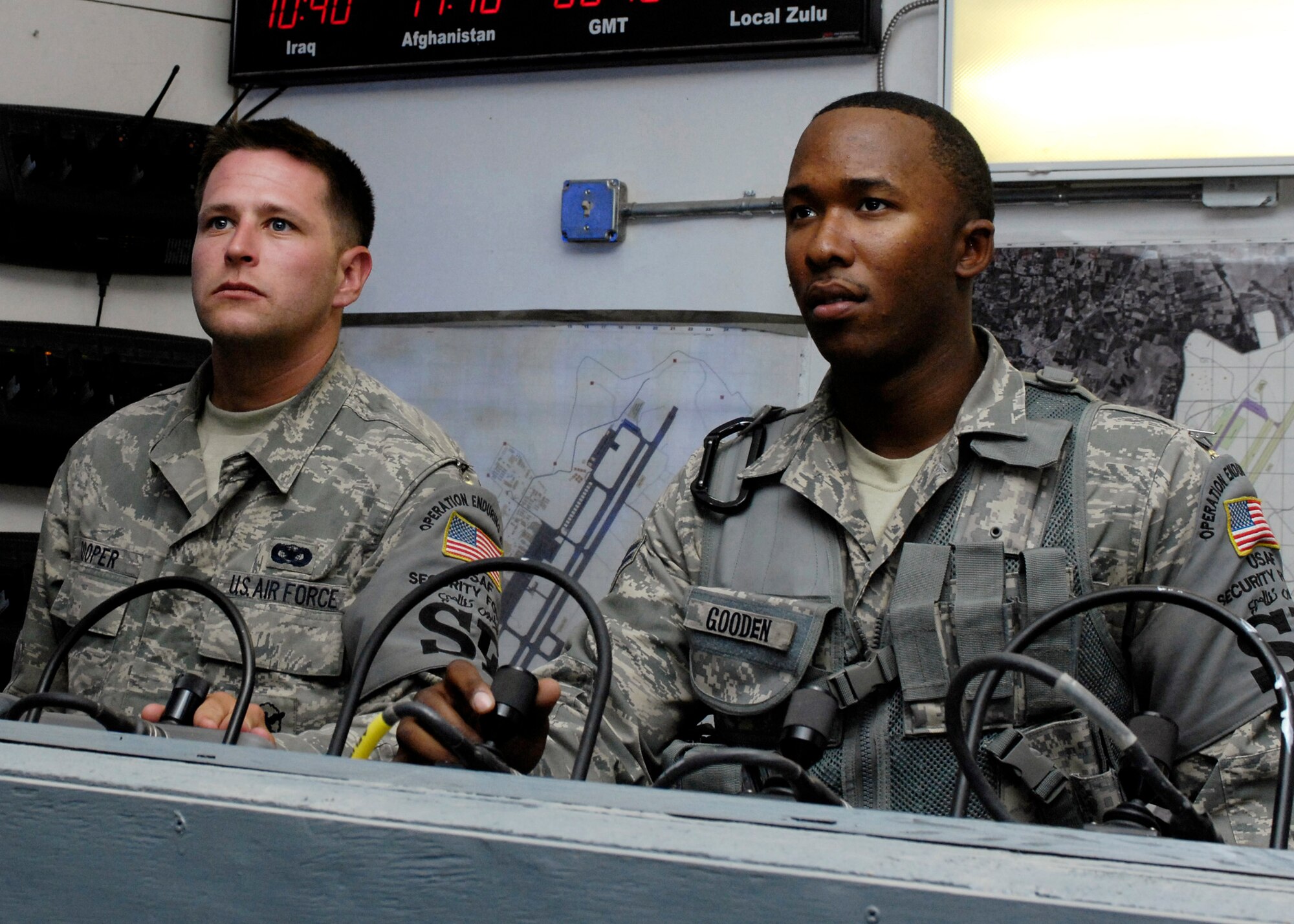 BAGRAM AIR FIELD, Afghanistan - Senior Airman Michael Cooper (left) and Airman 1st Class Jeremy Gooden, 455th Expeditionary Security Forces Squadron tactical automated sensor system controllers, monitor the flightline and perform visual assessments for alarm activations here June 5. Both members are deployed from the 355th Security Forces Squadron, Davis-Monthan Air Force Base, Ariz. (U.S. Air Force photo by Master Sgt. Demetrius Lester)