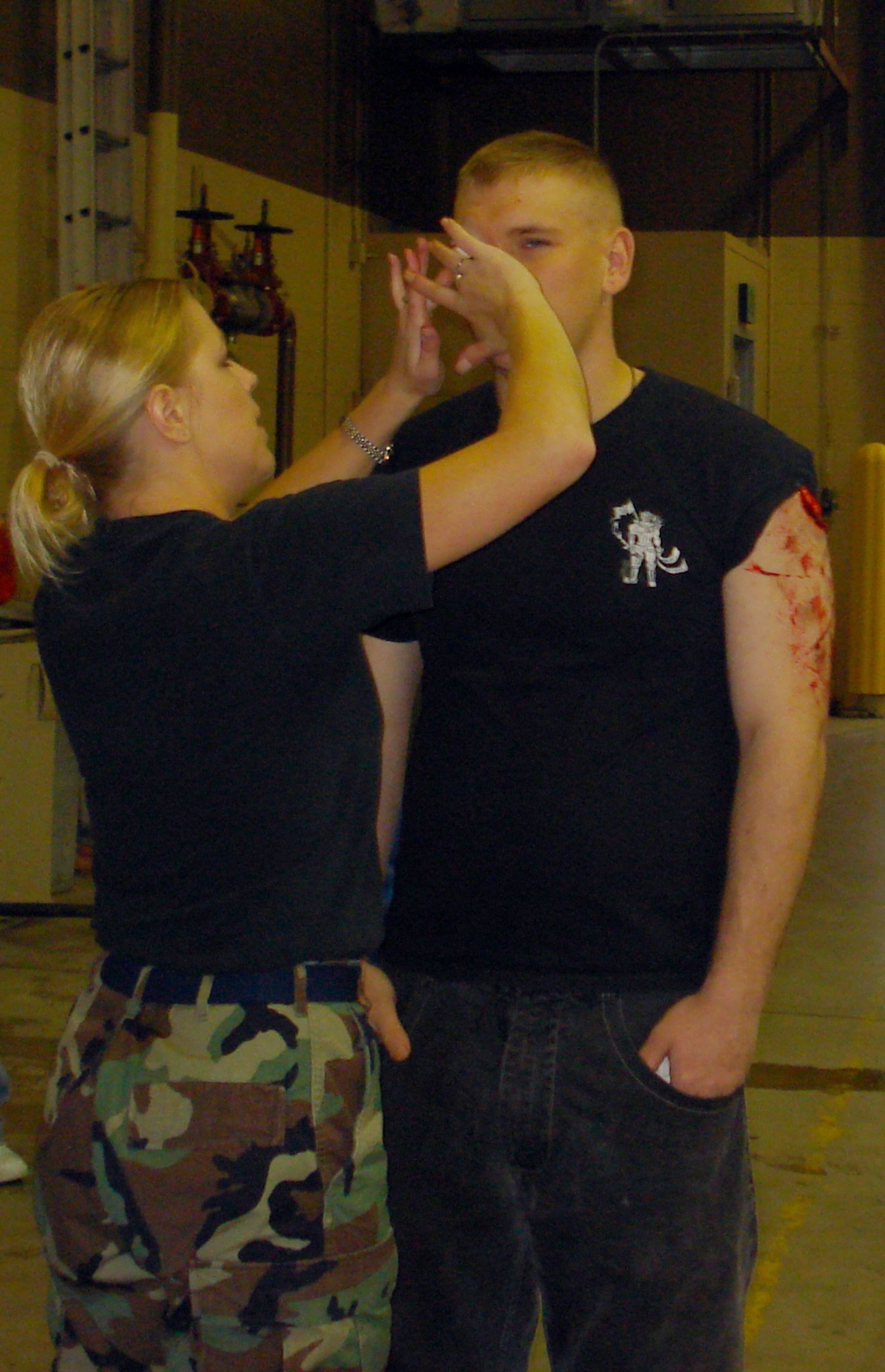 Tech. Sgt. Sarah Edwards, medical technician with the 341st Medical Operations Squadron, applies moulage to the face of a volunteer victim prior to the start of an exercise involving emergency medical personnel and the fire department at Malmstrom. (U.S. Air Force courtesy photo)                               
