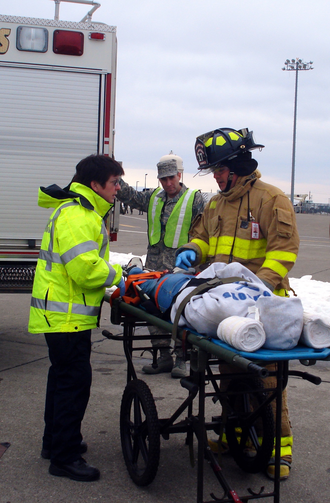 A member of the Malmstrom Fire Department reports his assessment of the victim's injuries to an emergency services medical technician during an exercise scenario at Malmstrom in April. An exercise evaluation team member observes. (U.S. Air Force courtesy photo)