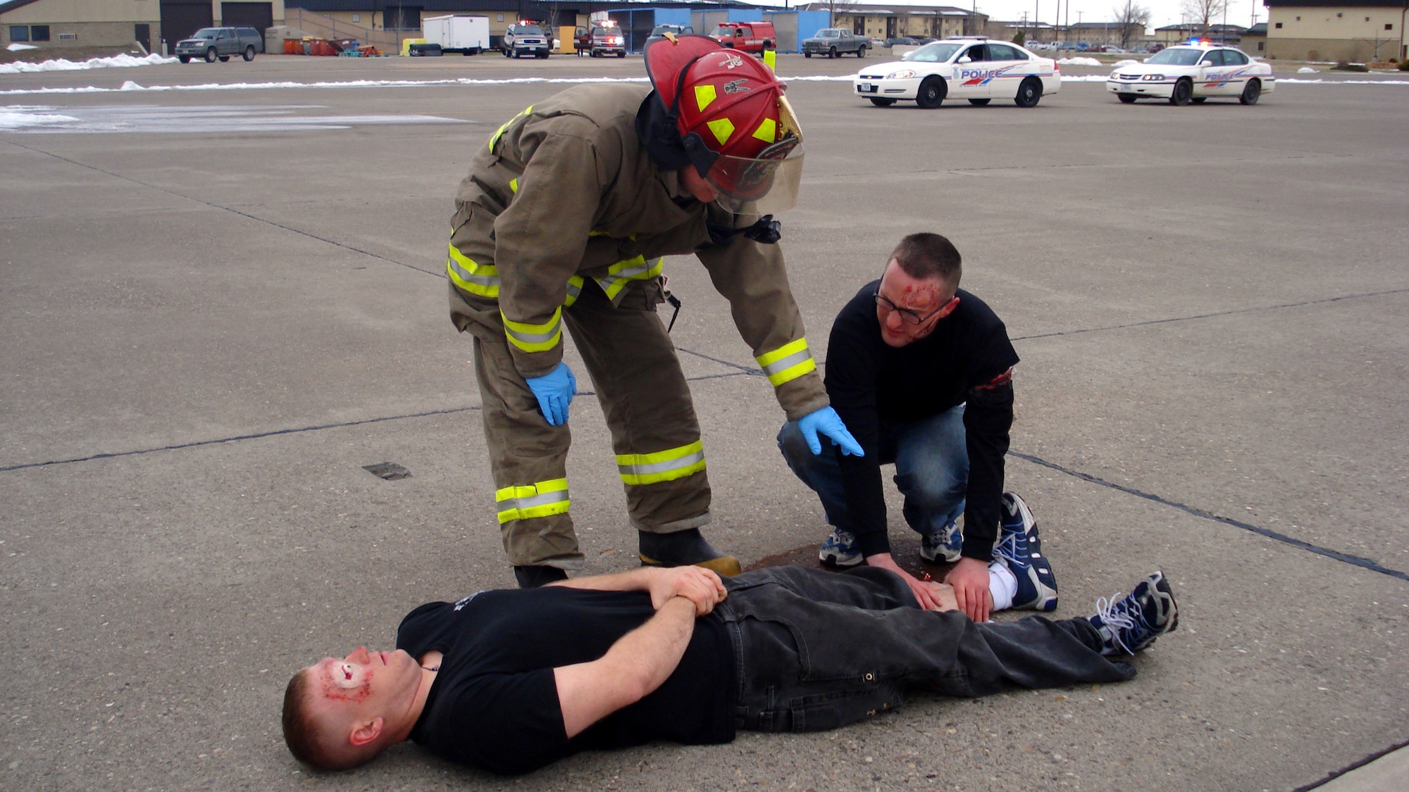 A member of the Malmstrom Fire Department and a volunteer "victim" assess the injuries of another "victim" during an exercise scenario in April. Both "victims" were moulaged prior to the start of the exercise to simulate a more realistic training environment. (U.S. Air Force courtesy photo)