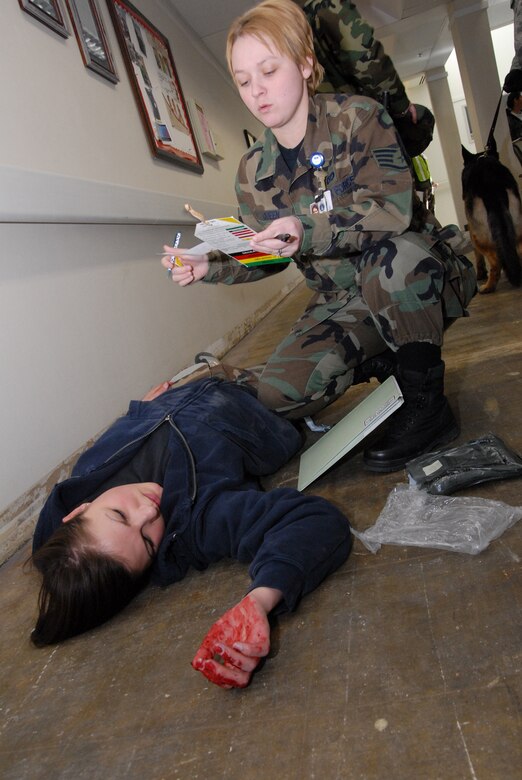 Staff Sgt. Mary Queen, 341st Medical Support Squadron, assesses a gunshot victim during a mass casualty exercise at the Malmstom Clinic in March. Moulaging victims for exercise scenarios enables medical personnel to better train for real-world possible situations when they deploy. (U.S. Air Force photo/John Turner)