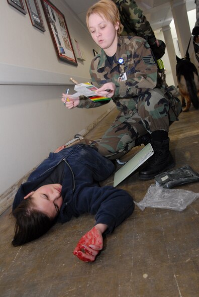 Staff Sgt. Mary Queen, 341st Medical Support Squadron, assesses a gunshot victim during a mass casualty exercise at the Malmstom Clinic in March. Moulaging victims for exercise scenarios enables medical personnel to better train for real-world possible situations when they deploy. (U.S. Air Force photo/John Turner)