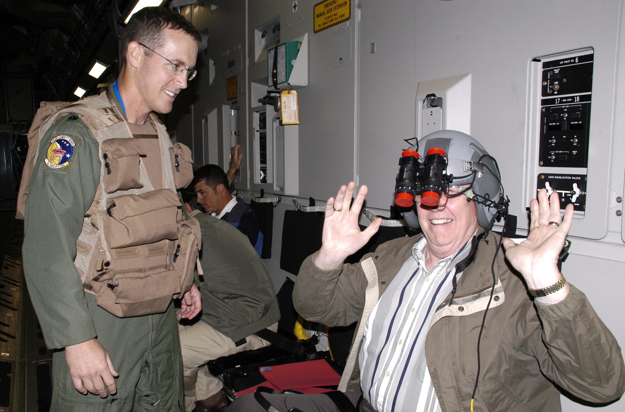 Lt. Col. Kevin Gordon, 3rd AS operations officer, gives Bob Mooney, Mayor of Camden, a chance to wear a standard-issue pilot’s helmet and night vision goggles. Mayor Mooney said he was excited to be able to be a part of the trip and this experience was something he'll always remember. (U.S. Air Force photo/Airman 1st Class Shen-Chia Chu)