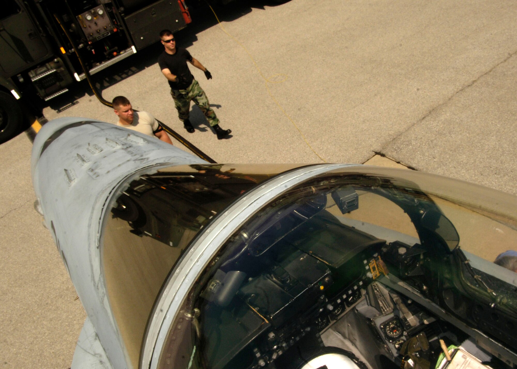SCOTT AIR FORCE BASE, Ill. -- This photo provides an interesting perspective or a “planes eye view” fuels management operators Staff Sgt. Ed Mueller (right) and Senior Airman Matthew Spatz as they work on the Scott flightline fueling navy fighter jets last week.
(US Air Force photo/ Airman First Class Megan Gilliland)
