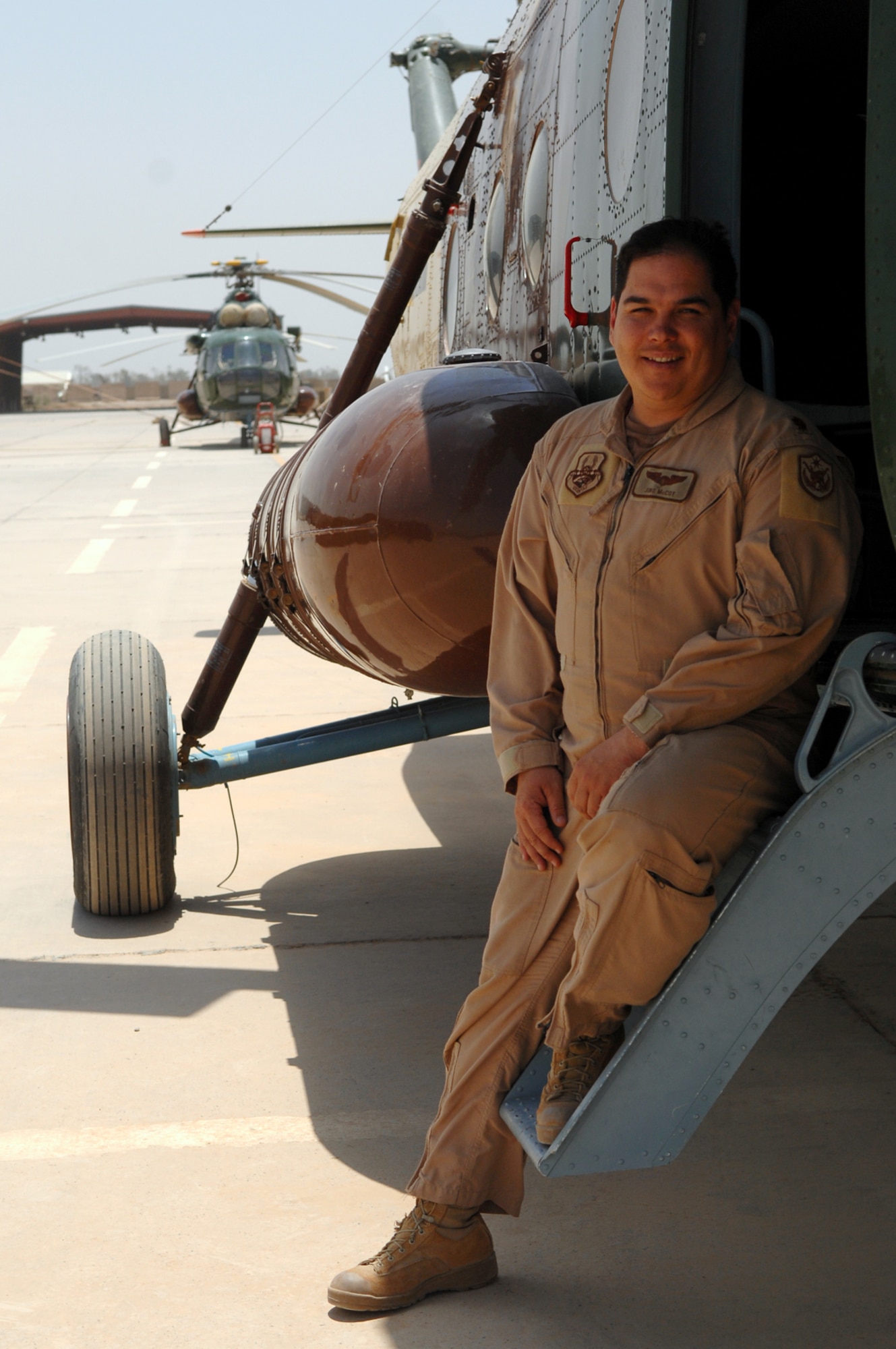 CAMP TAJI, Iraq -- Maj. Jiro McCoy, 770th Air Expeditionary Advisory Squadron,  Mi-17 [multi-role helicopter] commander of advisers, stands near the helicopter he trained Iraqis on during his 18-month deployment here. Major McCoy voluntarily extended his deployment by 12 months in order to assist the Iraqi air force in the tactical employment of the rotary wing being set up at Taji Base. Major McCoy is deployed from Fort Rucker, Ala. (U.S. Air Force photo/ Senior Airman Julianne Showalter)