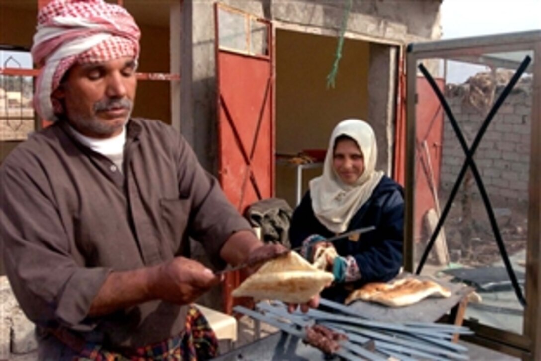 Hussen Jowd, a butcher in Arab Jabour, serves a sandwich at his newly renovated butcher shop and food stand, Kalsu, Iraq, June 4, 2008. Jowd received microgrants that enabled him to increase his stock and expand his business.

