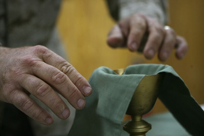 Petty Officer 1st Class Boyd W. Lewis, a religious program specialist, prepares for mass while at Camp Al Qa'im, Iraq, June 5. Cmdr. Paul J. Shaughnessy, a Catholic priest with Regimental Combat Team 5, who is from Worcester, Mass., is the only Catholic priest serving with RCT-5. Shaughnessy routinely travels throughout the regiments' area of operations and visits with Marines at various outposts.