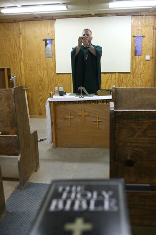Cmdr. Paul J. Shaughnessy, a Catholic priest with Regimental Combat Team 5, who is from Worcester, Mass, performs a Catholic mass June 5 at Camp Al Qa'im, Iraq. As the only catholic priest serving with RCT-5, Shaughnessy travels throughout the regiments area of operations and speaks with catholics and service members of various faiths about any issues they may have.