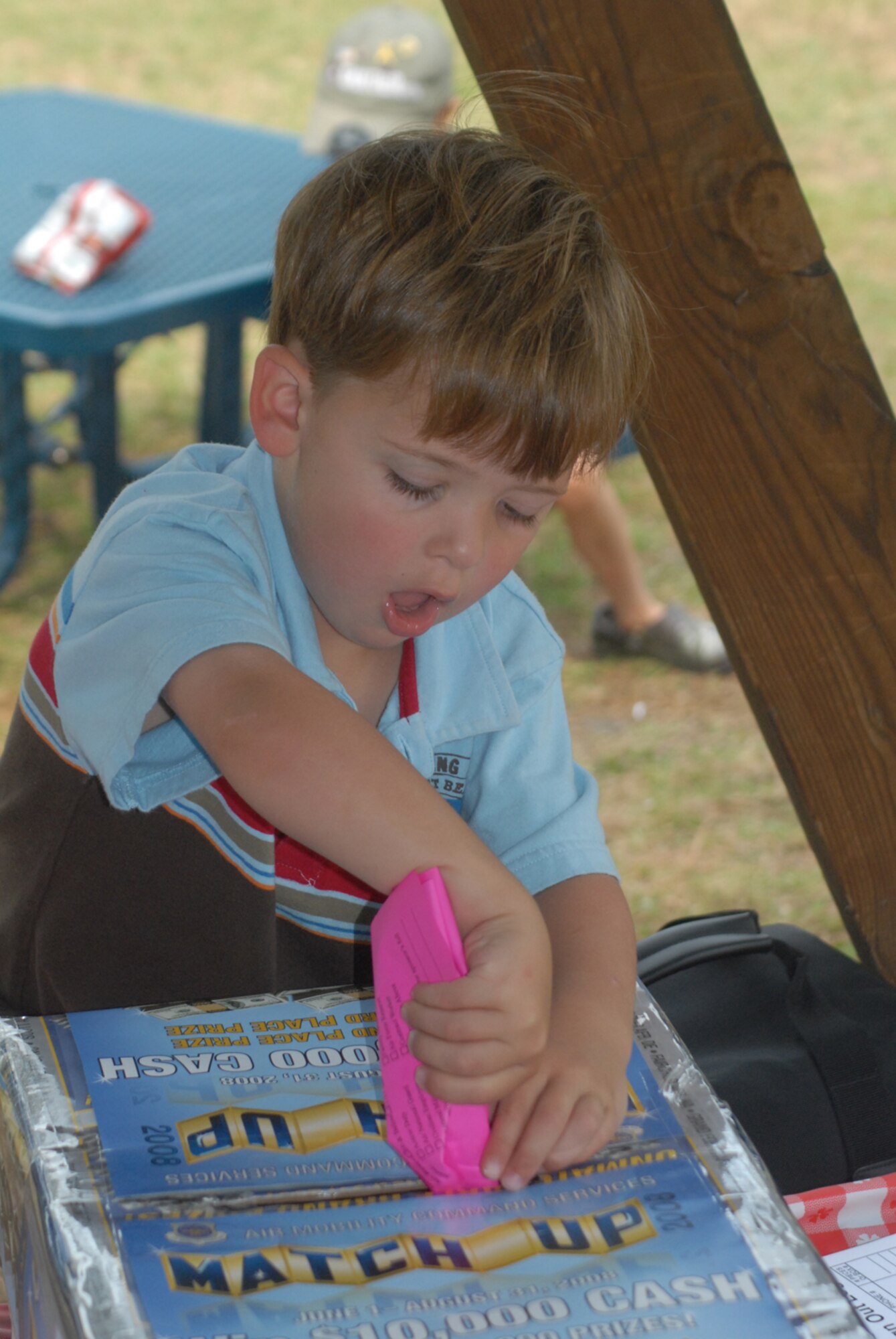 Carter Hudson, 3, stuffs an entry form into the Match Up box during the kickoff picnic Tuesday at the Pope Park.  To register for Match Up, go to www.amcmatchup.com. Contestants can enter to win cash and prizes through Aug. 31. (U.S. Air Force Photo by Airman 1st Class Mindy Bloem)