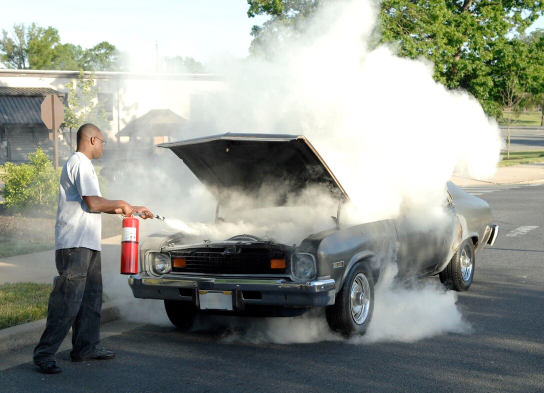 ANDREWS AFB, Md. -- Airman 1st Class Vincent Lewis uses a fire extinguisher to eliminate a fire in a 1974 Chevy Nova in front of Chapel 3 May 26. Airman Lewis quickly responded to the scene and extinguished the car fire prior to emergency personnel arriving, preventing a potentially deadly situation. Airman Lewis is assigned to the 316th Mission Support Squadron Military Personnel Flight. ( U.S. Air Force photo by Senior Airman Steven Doty)