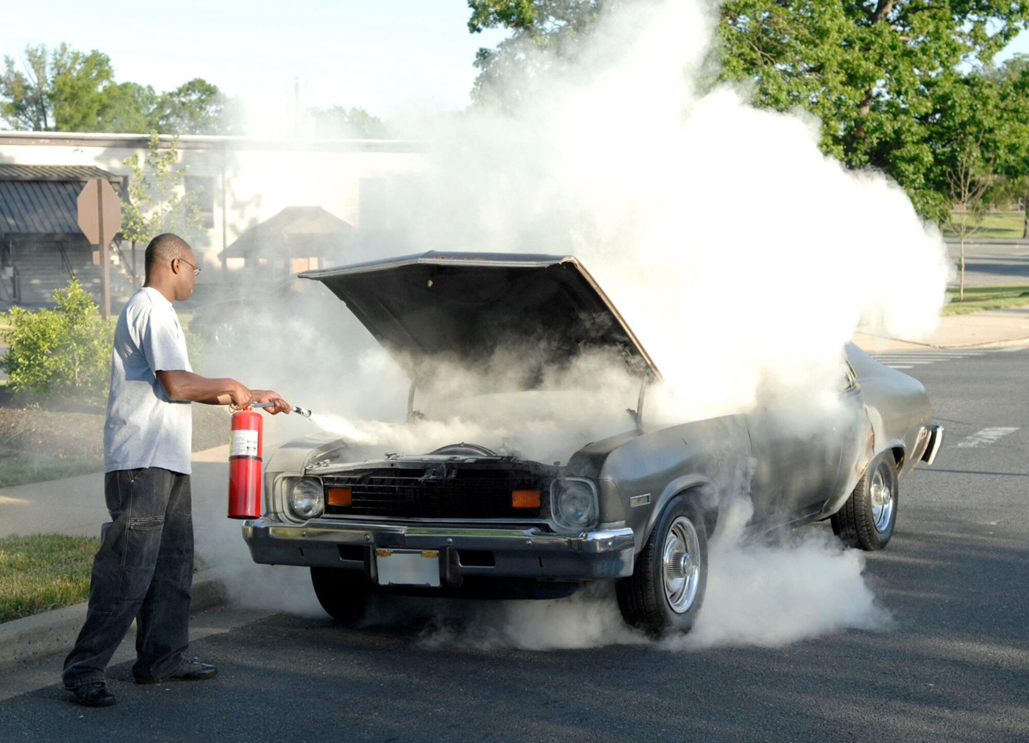 ANDREWS AFB, Md. -- Airman 1st Class Vincent Lewis uses a fire extinguisher to eliminate a fire in a 1974 Chevy Nova in front of Chapel 3 May 26. Airman Lewis quickly responded to the scene and extinguished the car fire prior to emergency personnel arriving, preventing a potentially deadly situation. Airman Lewis is assigned to the 316th Mission Support Squadron Military Personnel Flight. ( U.S. Air Force photo by Senior Airman Steven Doty)