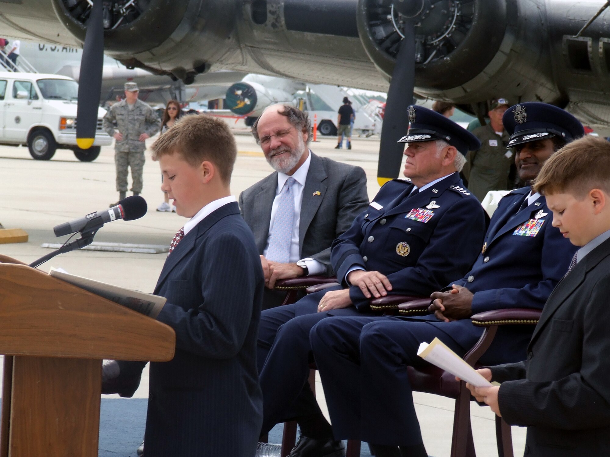 Brett Parlante, son of Master Sgt. Brett and Kelli Parlante of McGuire Air Force Base, N.J., reads his essay with the topic, "Above All, Remember Our Heroes Past and Present," during a wreath-laying ceremony at the McGuire Air Expo 2008 May 31.  Jadon Goodman, son of Master Sgt. Rodney and Julie Goodman, also from McGuire, also read his essay.  Both Brett and Jadon are sixth grade students in New Jersey's North Hanover School District's Upper Elementary School and were first place winners in an essay contest.  Watching them read their essay are New Jersey Governor Jon Corzine, Gen. Arthur Lichte, Air Mobility Command commander from Scott AFB, Ill., and Col. Balan Ayyar, 305th Air Mobility Wing commander at McGuire.  (U.S. Air Force Photo/Tech. Sgt. Scott T. Sturkol)