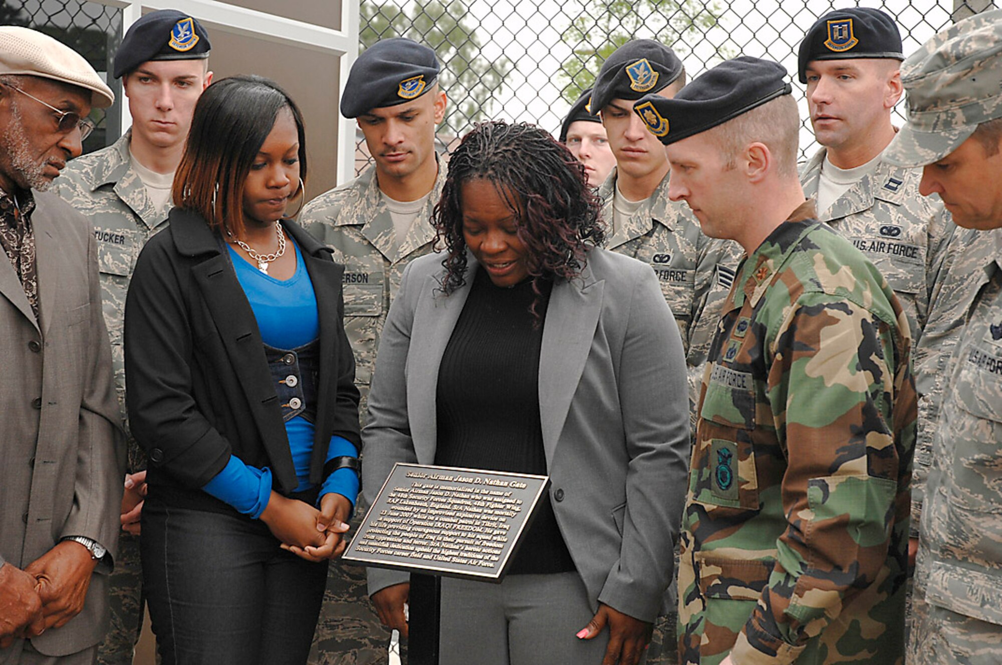 Senior Airman Jason D. Nathan's grandfather, sister and mother view a plaque at the new Senior Airman Jason D. Nathan Gate June 1 at Royal Air Force Lakenheath, England. The gate was dedicated to Airman Nathan who lost his life June 23, 2007, while on a combat patrol in Tikrit, Iraq. Members of Airman Nathan's unit and Maj. John Northon, the 48th Security Forces Squadron commander, offered support to his family. (U.S. Air Force photo/Senior Airman Brian J. Ellis) 
