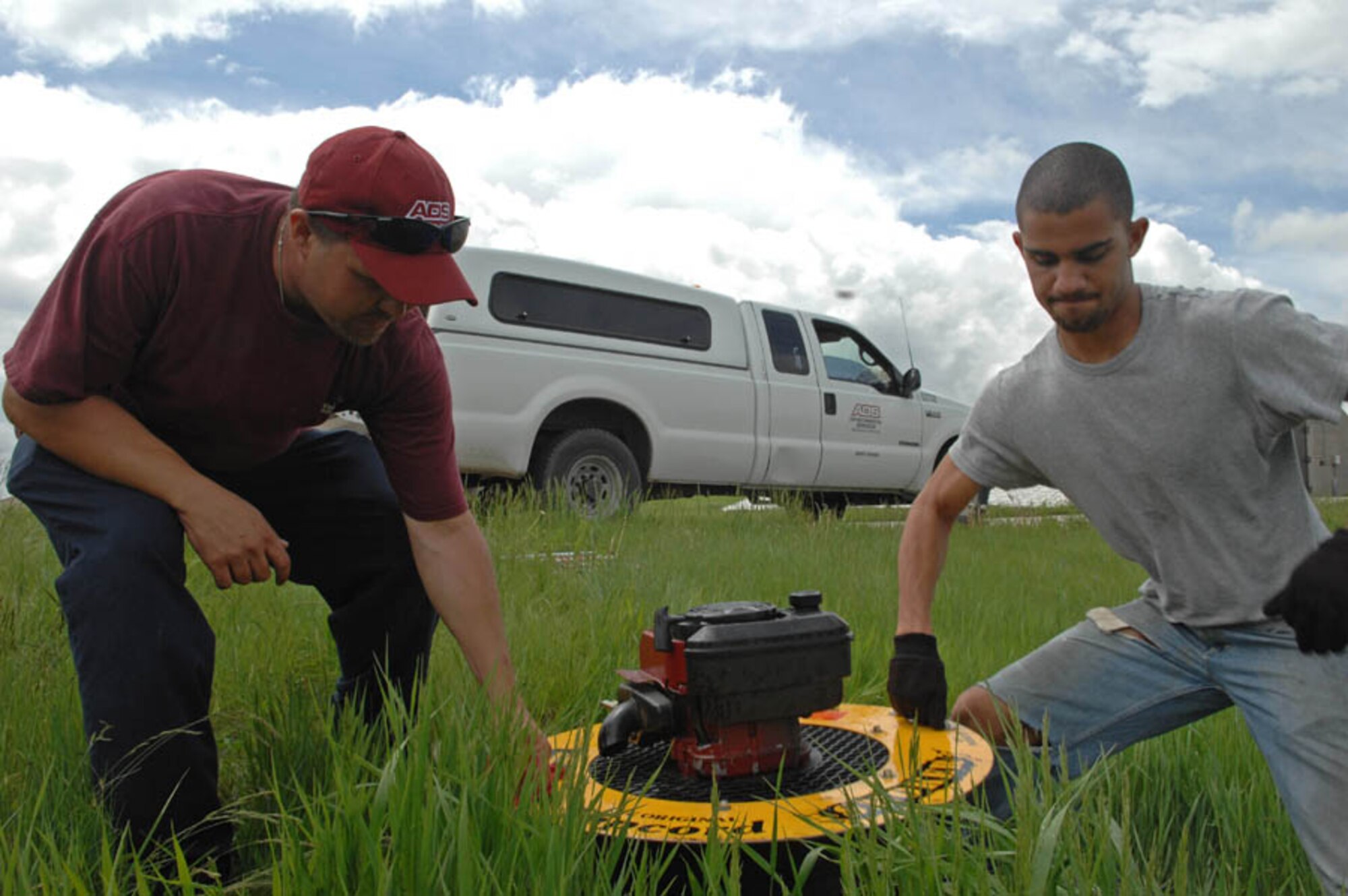 (Left) Woody Deason, American Digital Services crew leader, and Jason Harris, ADS sewer line smoke tester, set a smoke blower on a sewer opening to locate leaks in the piping system at Ellsworth Air Force Base, S.D., June 4, 2008. ADS performs the sewer smoke testing Air Combat Command wide to find cracks and other defects that need further attention. (U.S. Air Force photo/Airman Corey Hook)(Released)