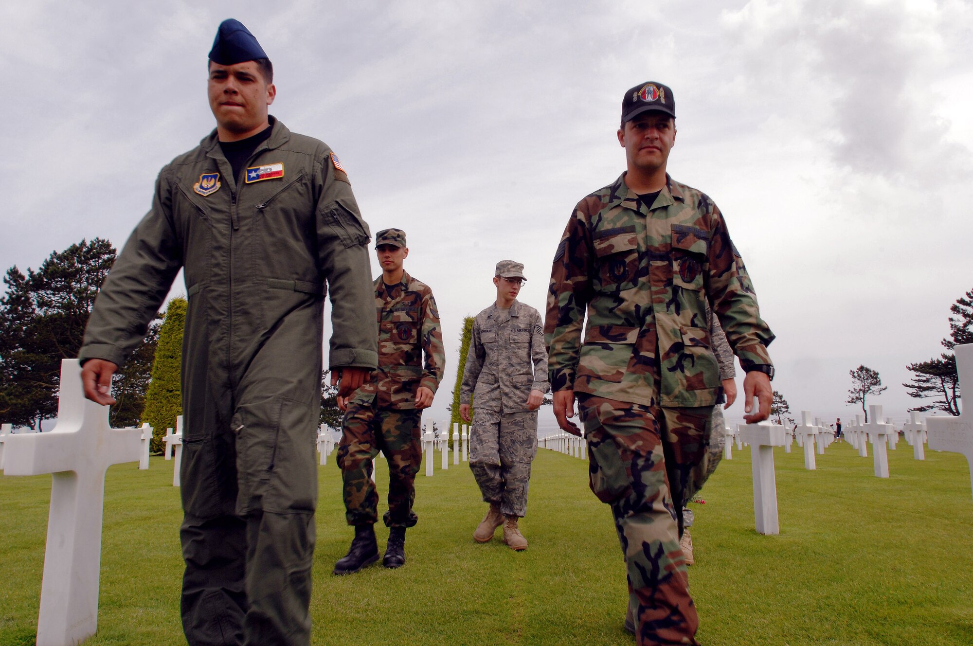 Staff Sgt. Mark Benavides (left to right), Staff Sgt. Jacob Dowrard, Airman 1st Class Mark Hayes and Tech. Sgt. Charles Garcia take a quiet walk to pay their respects to the fallen at the Normandy American Cemetery and Memorial June 5 in Saint Larent-sur-Mer, France. Sergeant Benavides is a crew chief with the 86th Operational Support Squadron, Sergeant Dowrard an integrated aviation specialist from the 86th Aircraft Maintenance Squadron, Airman Hayes is a crew chief from the 86th AXMS, and Sergeant Garcia is a C-130 Hercules mechanic from the 86th AXMS. All are from Ramstein Air Base, Germany, in Normandy to support D-Day commemorations. (U.S. Air Force photo/Airman 1st Class Amber Bressler) 
