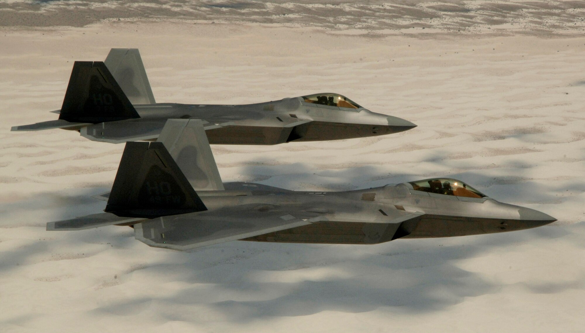 Col. Jeff Harrigian, 49th Fighter Wing commander, and Lt. Col. Mike Hernandez, 7th Fighter Squadron commander, fly F-22 Raptors June 2 over White Sands National Monument on the way to their home base, Holloman Air Force Base, N.M. (U.S. Air Force photo/Senior Airman Russell Scalf)