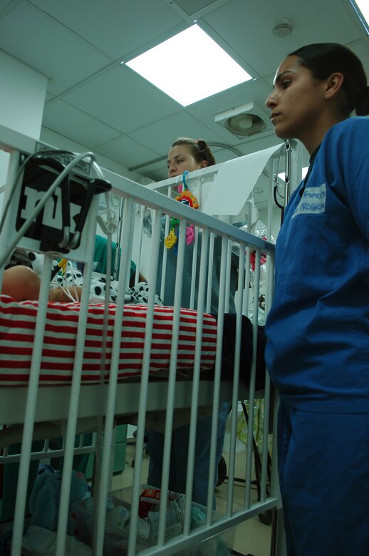 BALAD AIR BASE, Iraq -- Staff Sgt. C.J. Cruz-Francois, assigned to the 332nd Expeditionary Fighter Squadron, right, and Senior Airman Nicole Vaughn, assigned to the 23rd Expeditionary Fighter Squadron, look into the crib of an Iraqi toddler who suffered electrical burns after chewing through a power cord in his home. The Airmen were exposed to multiple facets of the hospital including the intensive care ward and unit, medical logistics, the physical therapy clinic and laboratory. Sergeant Cruz-Francois and Airman Vaughn are both deployed from Spangdahlem Air Base, Germany. (U.S. Air Force photo /Staff Sgt. Mareshah Haynes)