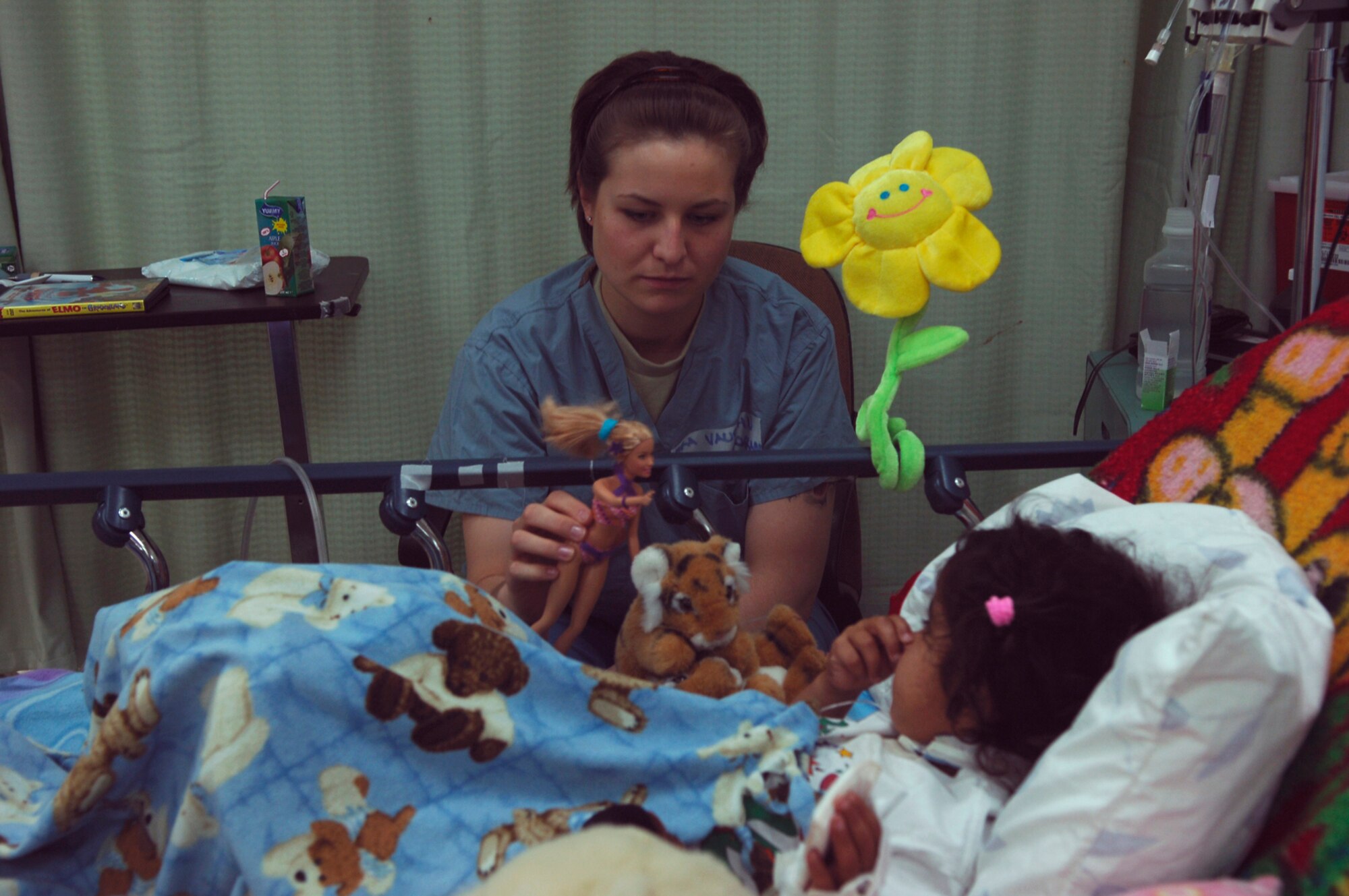 BALAD AIR BASE, Iraq -- Senior Airman Nicole Vaughn, assigned to the 23rd Expeditionary Fighter Squadron, spends time with a young Iraqi girl, a patient at the Air Force Theater Hospital here, as part of a job swap program. The program allows Airmen outside of the medical career field to spend a day shadowing hospital personnel. Airman Vaughn is deployed from Spangdahlem Air Base, Germany. (U.S. Air Force photo /Staff Sgt. Mareshah Haynes)