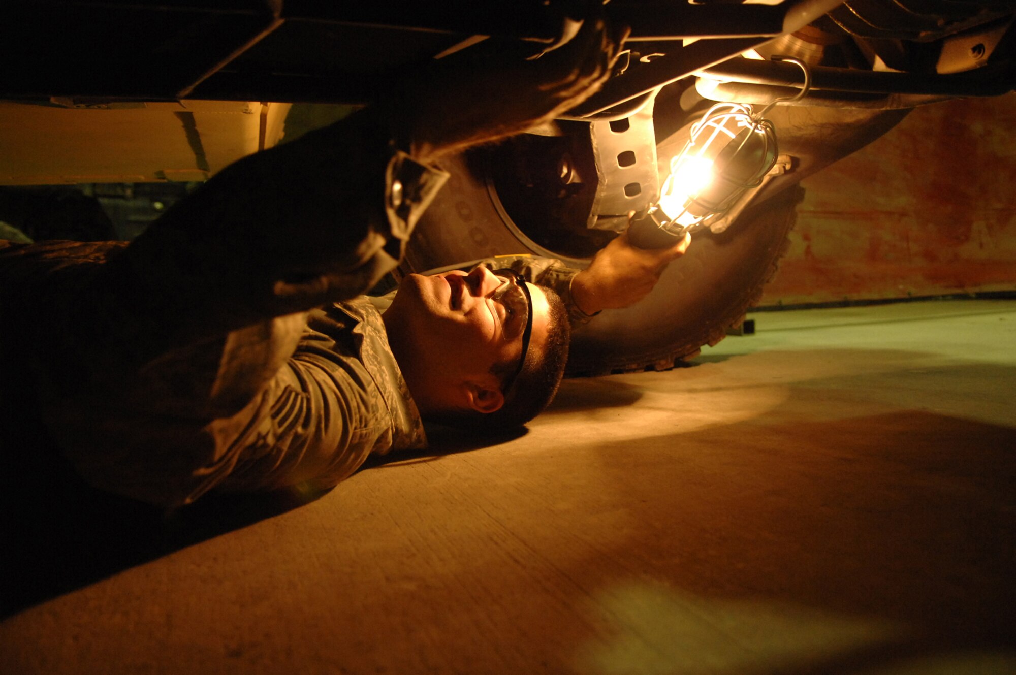 BALAD AIR BASE, Iraq -- Senior Airman James Valdiviez, 332nd Expeditionary Logistics Readiness Squadron vehicle mechanic, looks at the undercarriage of a new HUMMV to ensure it meets the specifications of the receiving unit and is fully operational before releasing it for combat operations here, June 4. Humvees are used throughout Iraq for tactical and non-tactical operations. Airman Valdiviez is deployed from Eielson Air Force Base, Alaska. (U.S. Air Force photo/ Senior Julianne Showalter