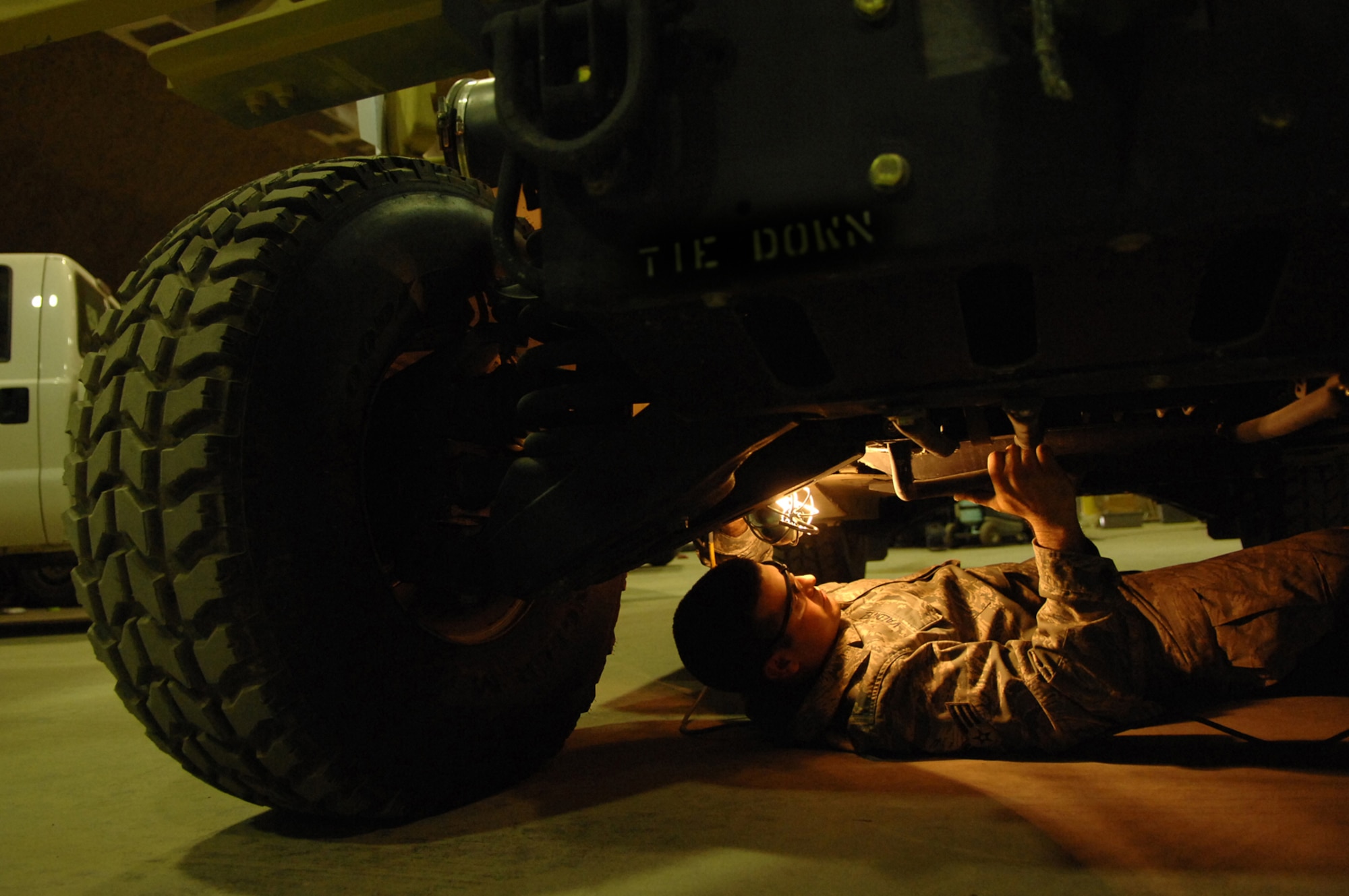 BALAD AIR BASE, Iraq -- Senior Airman James Valdiviez, 332nd Expeditionary Logistics Readiness Squadron vehicle mechanic, inspects the undercarriage of a new humvee here, June 4. Humvees are made to order and, once received, are inspected to ensure they meet the specifications of the gaining unit. Airman Valdiviez is deployed from Eielson Air Force Base, Alaska. (U.S. Air Force photo/ Senior Julianne Showalter)