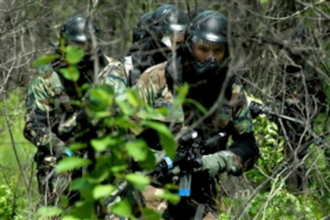 In special protective gear for paintball use, U.S. Air Force Senior Airman Christopher Brewer leads the way June 2, 2008, at Camp Gilbert C. Grafton, N.D.  The security force members are participating in realistic war-time tactics using paintball weapons to confirm shot placement. 