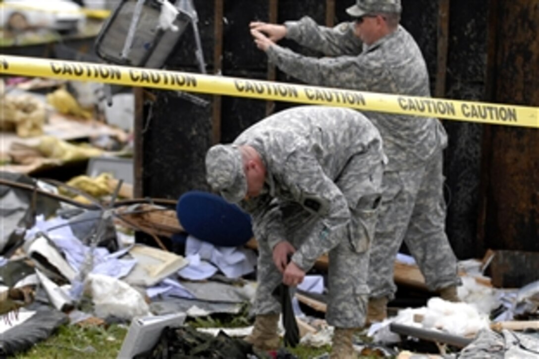 U.S. soldiers go through debris after a tornado ripped through Camp Atterbury, Ind., June 3, 2008. No injuries were reported, but more than 40 buildings and numerous military and civilian vehicles were destroyed during the storm. The soldiers are assigned to the 205th Infantry Brigade. 