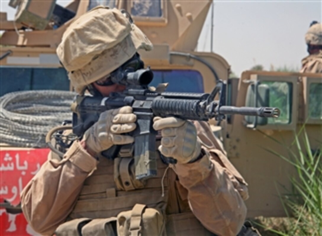 A U.S. Marine from Charlie Company, 1st Battalion, 6th Marine Regiment, 24th Marine Expeditionary Unit, International Security Assistance Force looks through the scope of his 5.56 mm M-4 carbine rifle during operations in Garmsir, Helmand Province, Afghanistan, on April 29, 2008.  