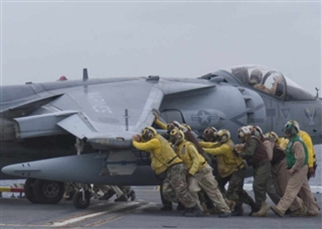U.S. Navy crewmembers push an AV-8B Harrier aircraft onto an aircraft elevator aboard the Wasp class amphibious assault ship USS Essex (LHD 2) on April 29, 2008.  The Essex is the lead ship of a forward ñdeployed U.S. Expeditionary Strike Group.  