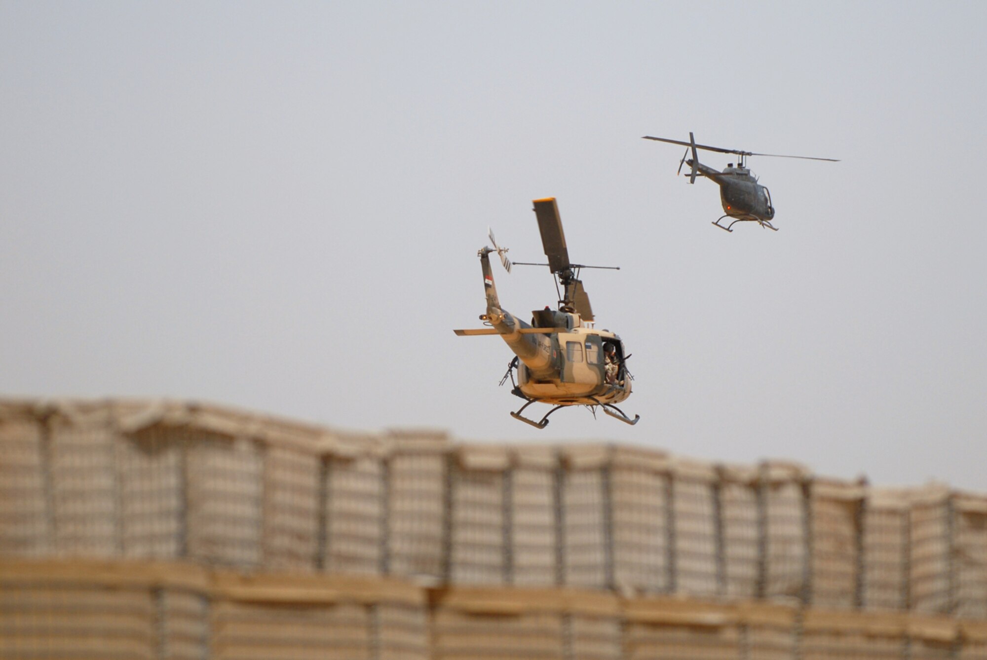 CAMP TAJI, Iraq -- An Iraqi air force UH-1 Huey II and a U.S. Army OH-58 Kiowa fly in formation over Camp Taji during an aerial gunner and helicopter training mission, May 28. U.S. Airmen, assigned to the 770th Air Expeditionary Advisory Squadron, teach the Iraqi aerial gunners and pilots how to carry out their missions in the skies to become a self sustaining force in their country. (U.S. Air Force photo/ Senior Airman Julianne Showalter)